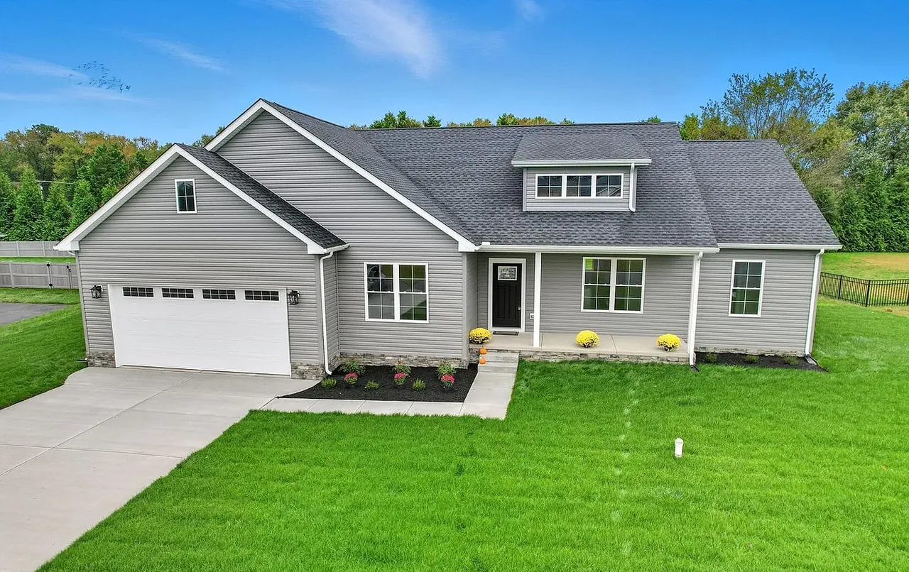 Front elevation of a grey ranch-style new build with a paved driveway
