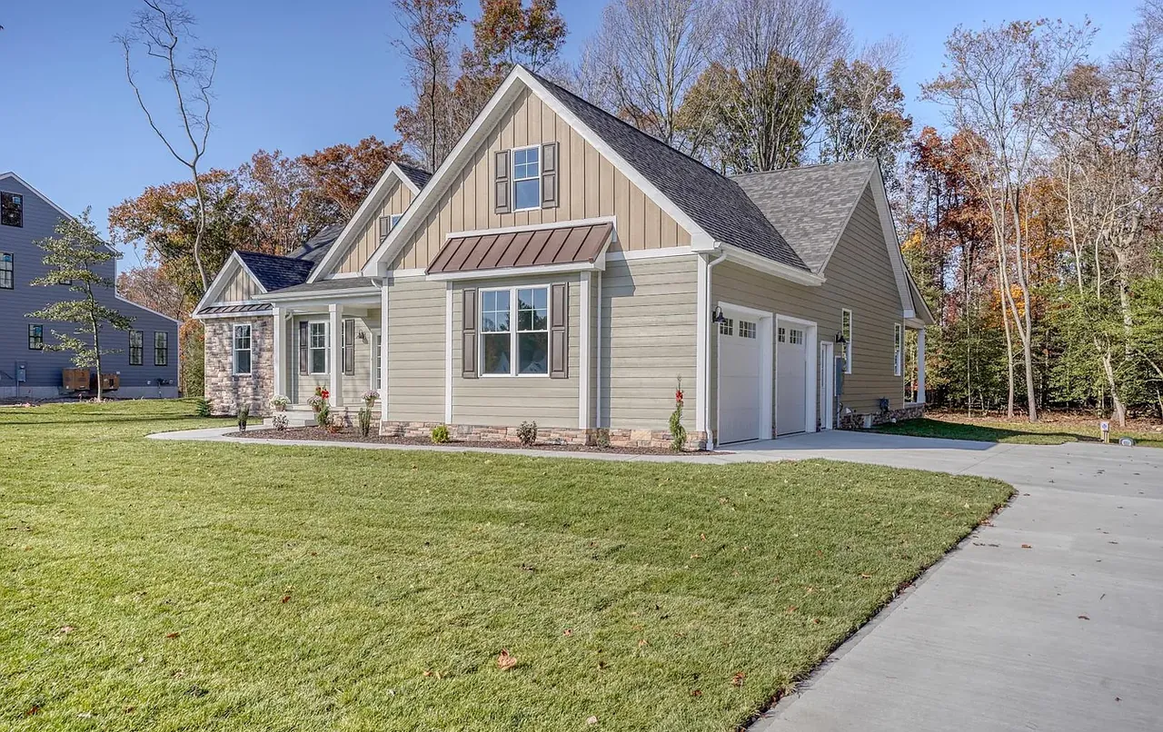 Board-and-batten and lap-sided new home with finished driveway in autumn