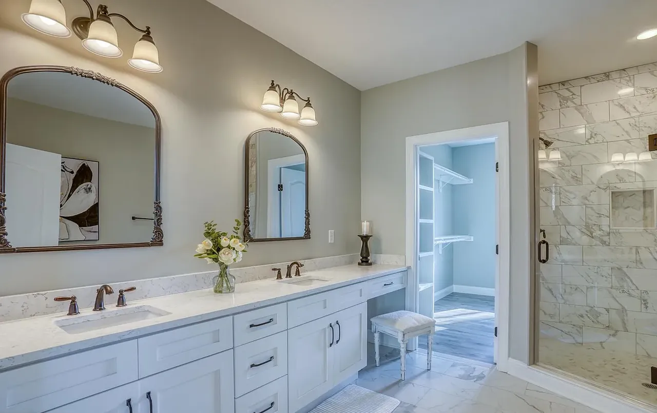 Primary bathroom with double vanity, make-up station and glass shower